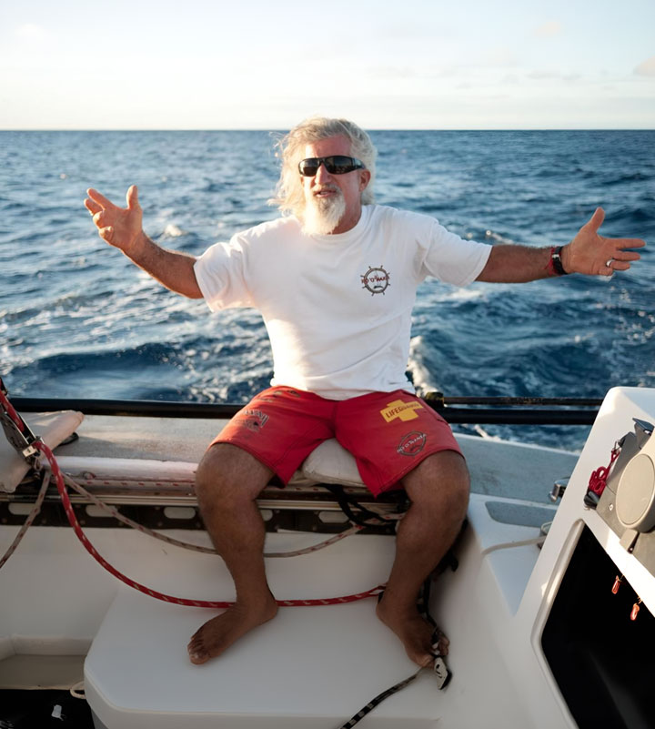 Captain Don, full-time captain of the Hoʻo Nanea catamaran, smiling and welcoming guests while sailing off Oahu, Hawaii.